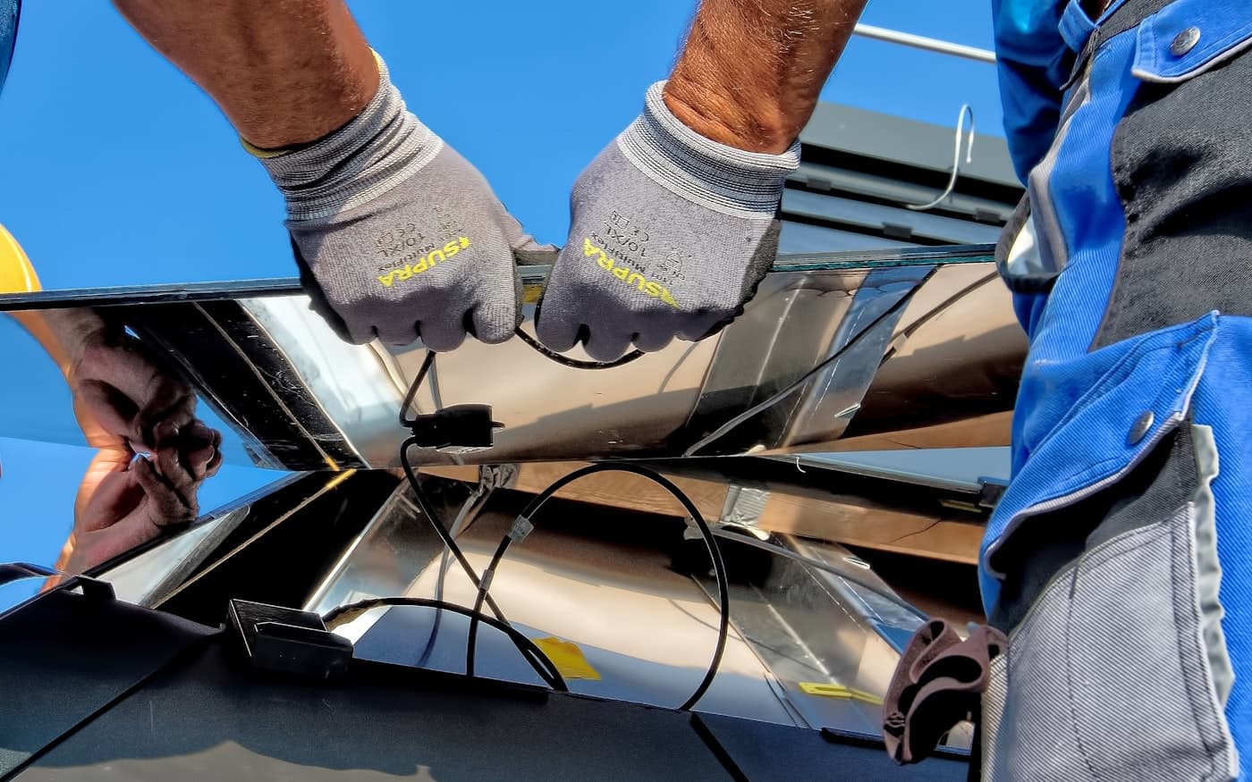 Técnicos instalando paneles solares en el techo de una casa